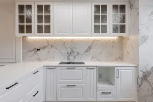 유리 도어 상부장과 대리석 벽면의 클래식 주방